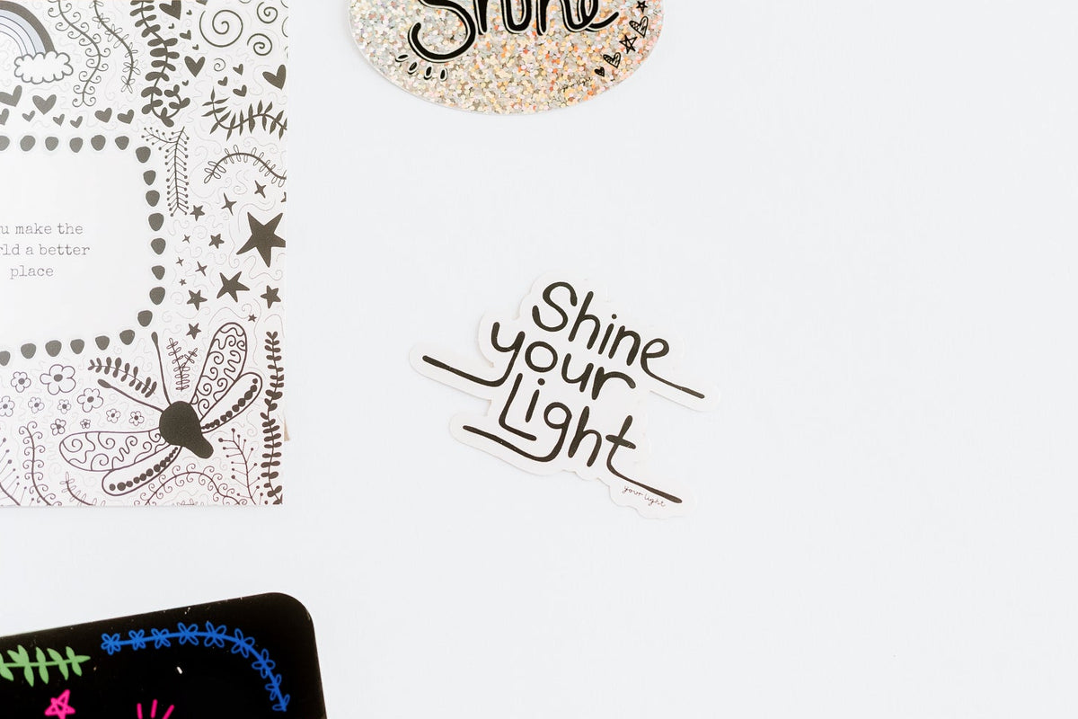 A styled flat-lay of stickers and a greeting card on a clean white background.
